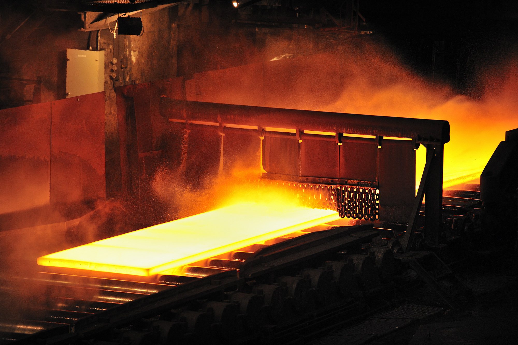 Example from a hot rolling mill: A glowing slab is transported on a roller table 